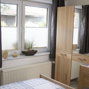 Schlafzimmer mit Doppelbett und großem Kleiderschrank